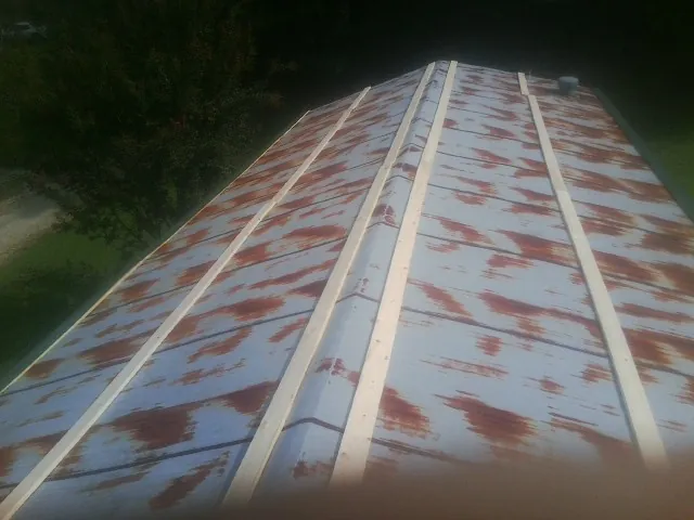 Rusted metal roof panels with new wood purlins before replacement — Storm Damage Roof Repair in Galeton by Roofing Brothers