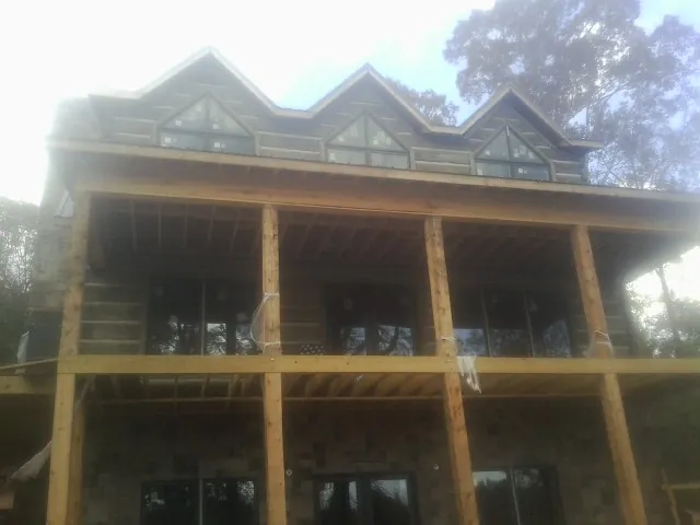 Dormers and porch framing on a large log home under construction — Roof Coating work by our crew in Galeton