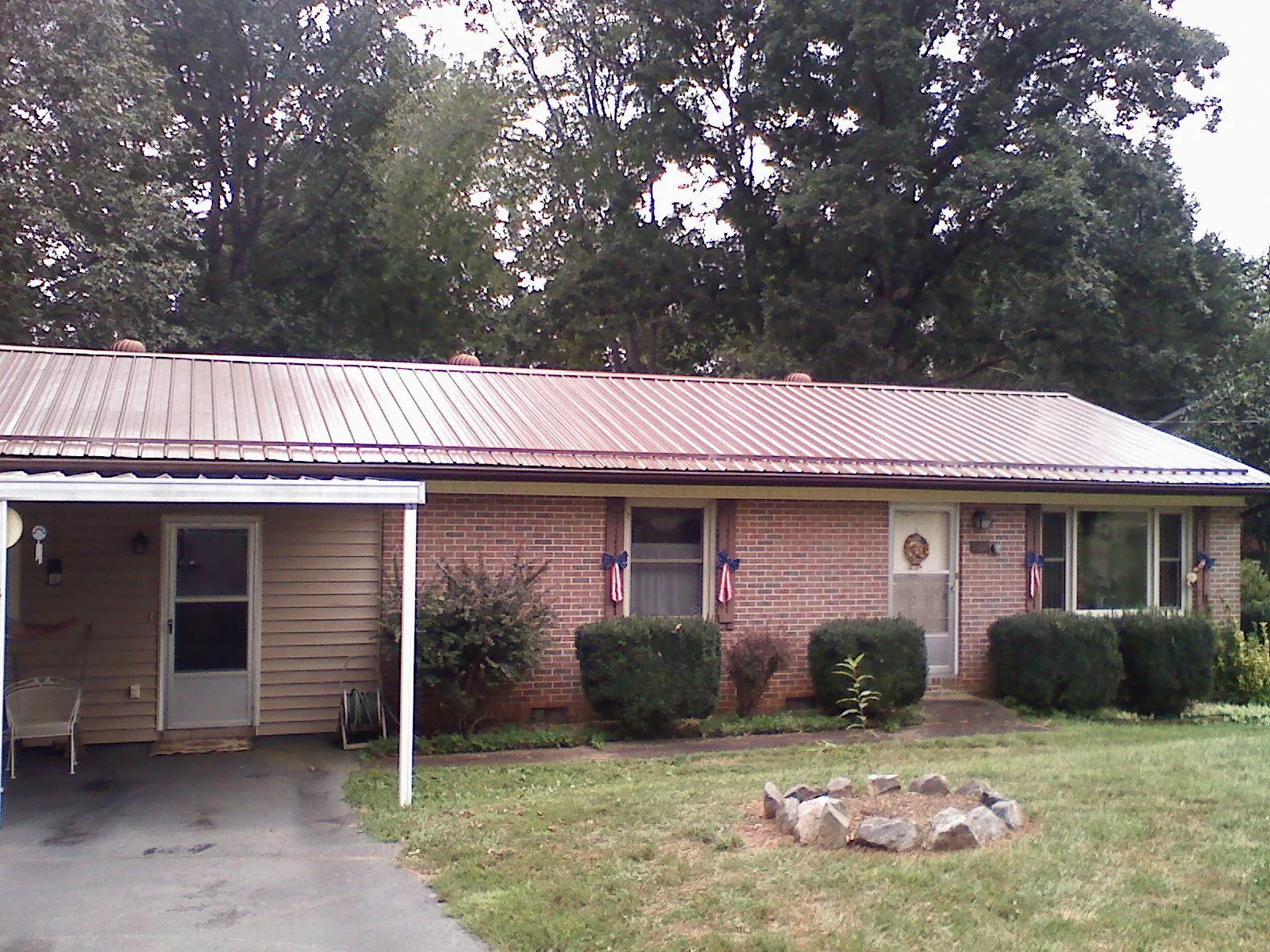 Bronze metal roof and carport on a brick ranch home — Roof Repair work by our crew in Galeton